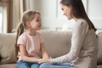 mother talking to her daughter on the couch