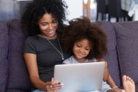 Mother and child talking to someone on a laptop